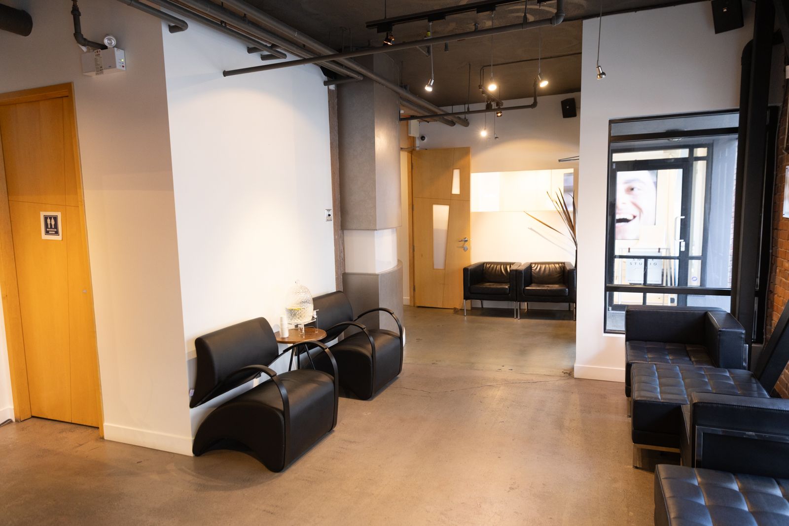The waiting room: black leather, poured concrete, exposed pipe