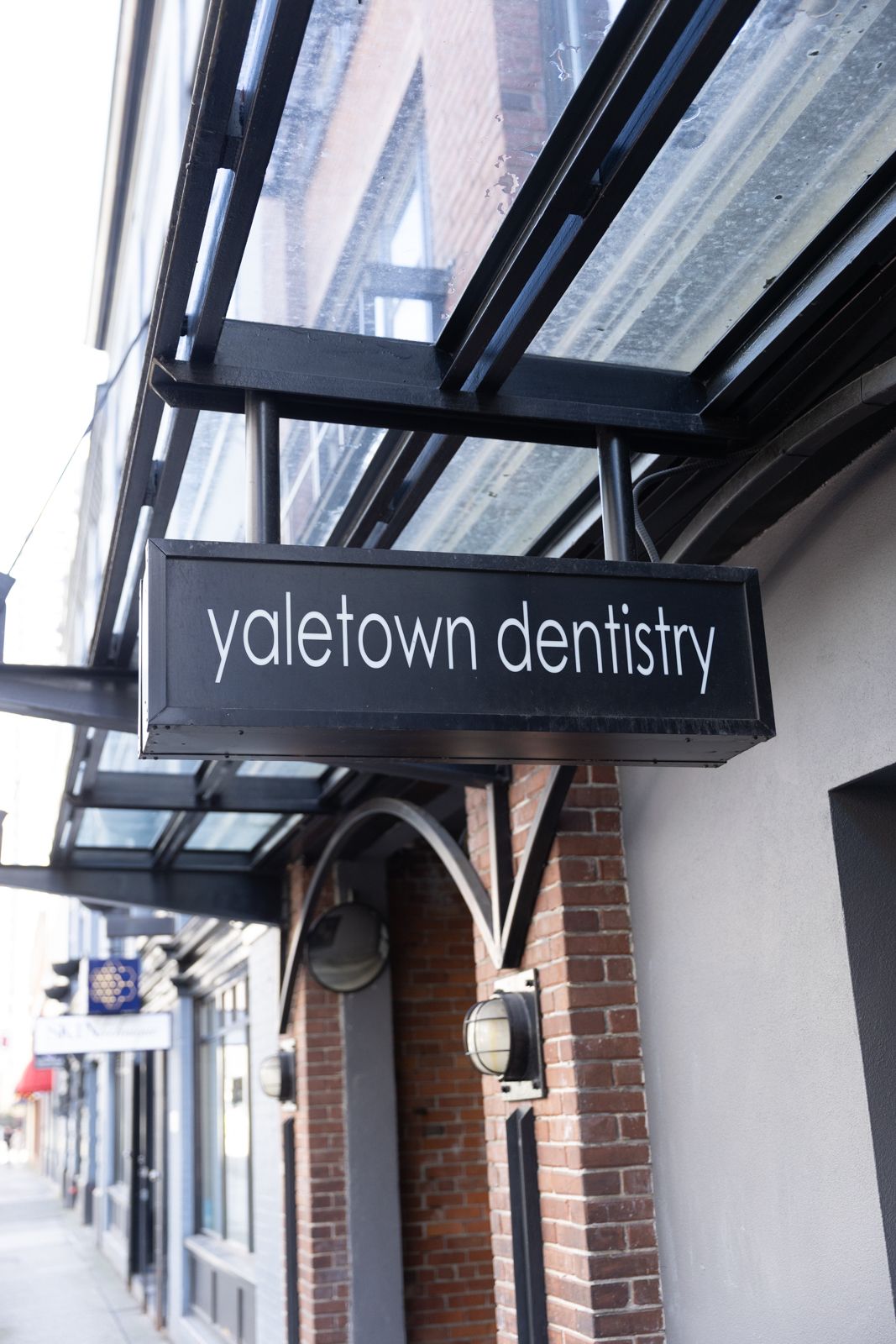 The Yaletown Dentistry blade sign against the brick